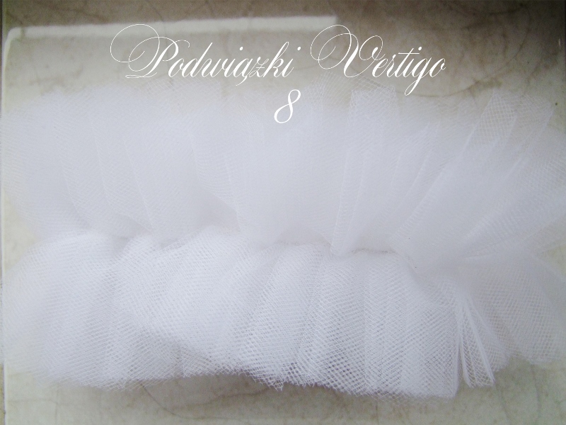 garter made of tulle. White, front silver brooch and transparent crystals, reflecting the different colors of light