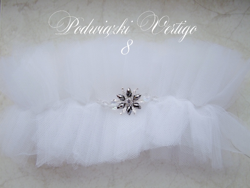 garter made of tulle. White, front silver brooch and transparent crystals, reflecting the different colors of light